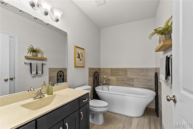 Bathroom with a soaking tub, vanity, and wood tiled floors