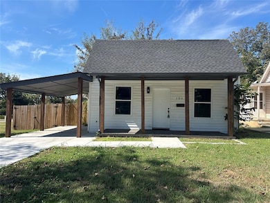 Front view with shingled roof and welcoming covered porch.