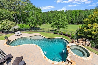 For added ambiance, the space includes a 80-inch outdoor TV, an integrated surround sound system with discreet rock speakers, and a professionally landscaped yard that extends to the tree line and is fully fenced for privacy and peace of mind.