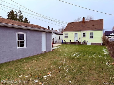 Back of house with a yard and concrete block siding