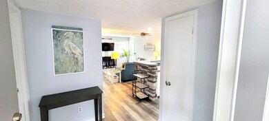 Hall featuring a textured ceiling and light wood-s