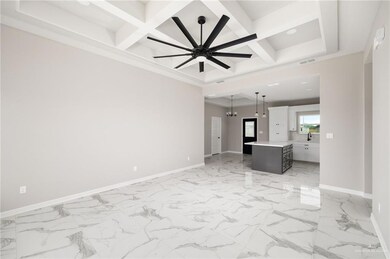 Spare room featuring light tile flooring, coffered ceiling, ceiling fan with notable chandelier, and beamed ceiling