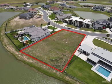 Aerial perspective of suburban area featuring a large body of water and property boundaries highlighted