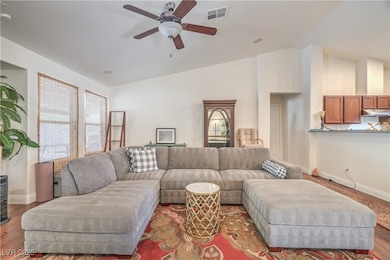 Living room with healthy amount of natural light, ceiling fan, wood finished floors, and high vaulted ceiling