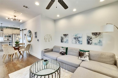 Living room featuring a barn door, ceiling fan, r