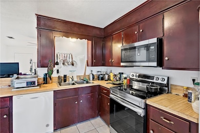 Kitchen with a sink, dark brown cabinets, applianc