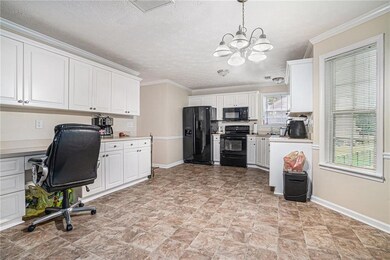 Office with baseboards, a chandelier, crown moldin