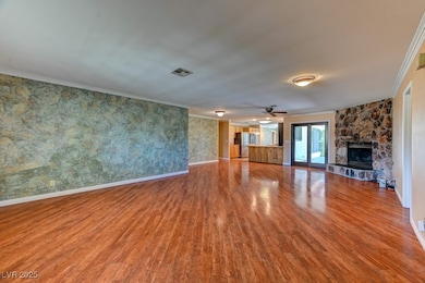 Unfurnished living room with crown molding, wood f