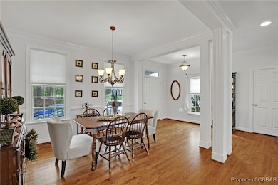 Dining space with light wood-style floors, crown m