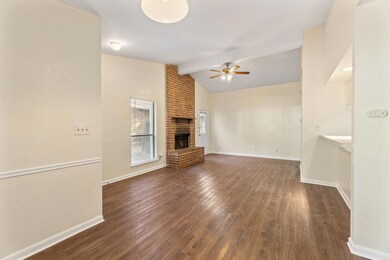 Unfurnished living room with dark wood-type flooring, a fireplace, and a ceiling fan