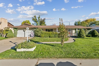 Ranch-style house featuring driveway, a garage, a front lawn, and brick siding