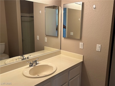 Bathroom with a textured wall and vanity