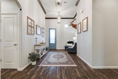 Entryway with crown molding, visible vents, basebo