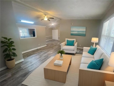 Living area with baseboards, lofted ceiling with b