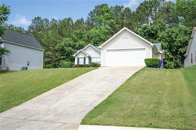 View of front of house with a garage, a front yard, driveway, and cooling unit