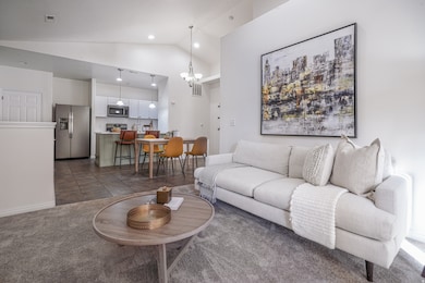 Living room featuring a chandelier, dark colored carpet, high vaulted ceiling, dark tile patterned floors, and recessed lighting