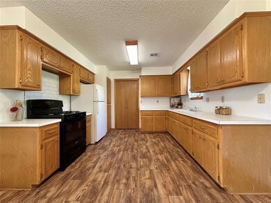 Kitchen featuring a textured ceiling, black range 