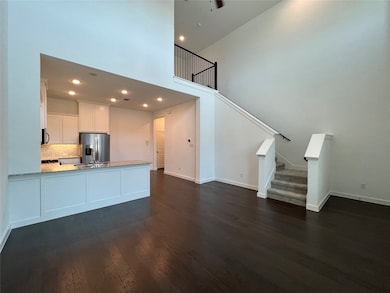 Kitchen featuring a high ceiling, white cabinets, recessed lighting, a peninsula, and stainless steel appliances