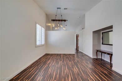 Unfurnished room featuring a high ceiling, wood fi