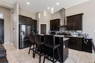 Kitchen, range hood, decorative backsplash, tiled marble look finished floor, and stainless steel appliances