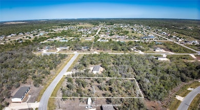 Aerial overview of property's location with property boundaries highlighted and a heavily wooded area