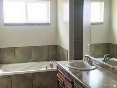 Primary full bath featuring double vanity, deep soaking tub, and separate shower