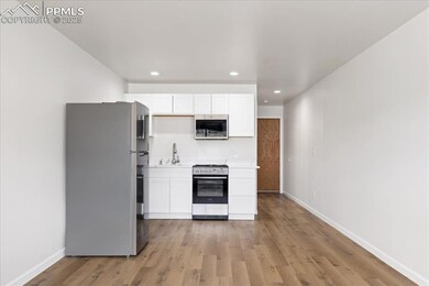 Kitchen featuring appliances with stainless steel finishes, white cabinets, recessed lighting, light wood-style floors, and light countertops