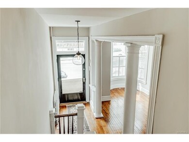 Entry from exposed staircase, original columns and