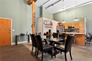 Dining area featuring rail lighting, concrete floo
