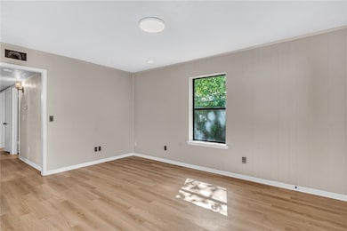 Empty room with light wood-type flooring and baseboards