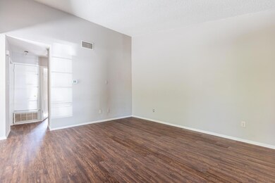 Spare room featuring a textured ceiling and dark wood finished floors