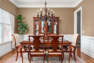 Dining Room with triple window, picture frame wainscoting & chair rail