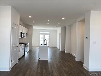 Kitchen with french doors, a kitchen island with sink, stainless steel appliances, white cabinets, and dark hardwood / wood-style flooring