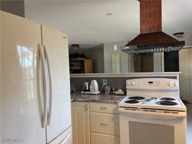 Kitchen featuring white cabinetry, island exhaust