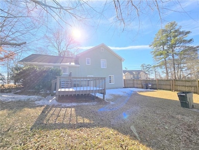 Rear view of property with a deck and a lawn