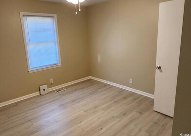 Spare room featuring baseboards and light wood-type flooring