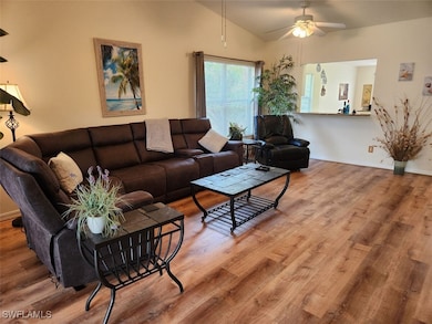 Living room featuring vaulted ceiling, hardwood / wood-style floors, and ceiling fan