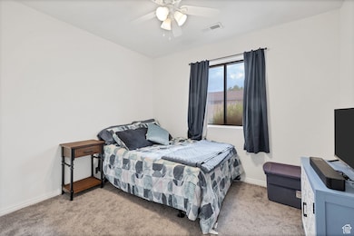Bedroom featuring light carpet and ceiling fan