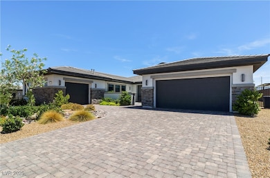 Prairie-style home with stone siding, a garage, st