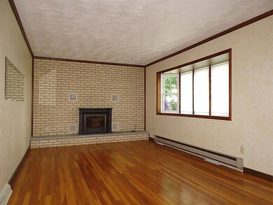 Living Room with large bay window, brick accent wa