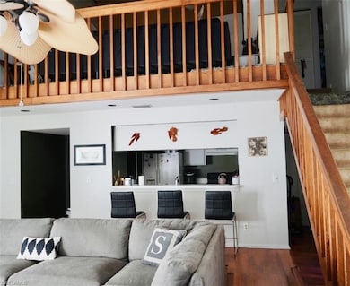 Living area with baseboards, ceiling fan, stairs, 