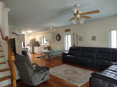 Living room featuring stairway, a ceiling fan, cro