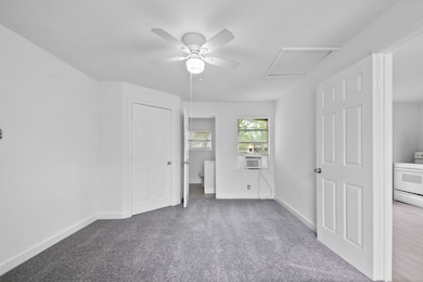 This room features fresh white walls, a ceiling fa