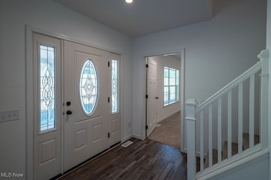 Foyer featuring dark wood finished floors, stairs, and recessed lighting