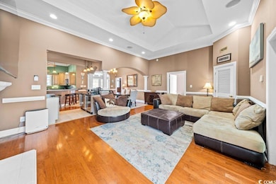 Living room with ceiling fan with notable chandeli