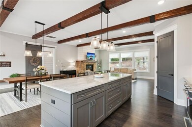 Kitchen featuring a stone fireplace, light stone c