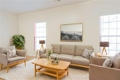 Living room with baseboards, a healthy amount of sunlight, and wood finished floors