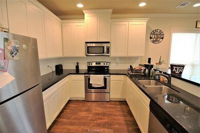 Kitchen with dark stone countertops, sink, white c
