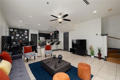 Living area featuring light tile patterned flooring, visible vents, ceiling fan, and recessed lighting