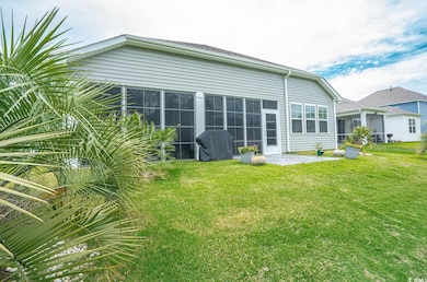 Back of house with a lawn and a patio